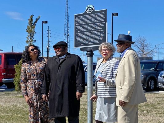 group of four African American men and women with trail marker